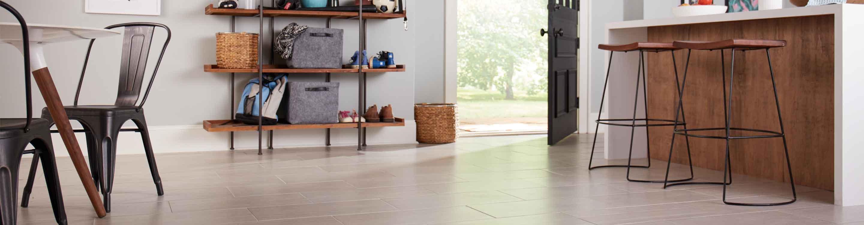 Large-format light brown tile in modern kitchen with wood island and metal frame barstools